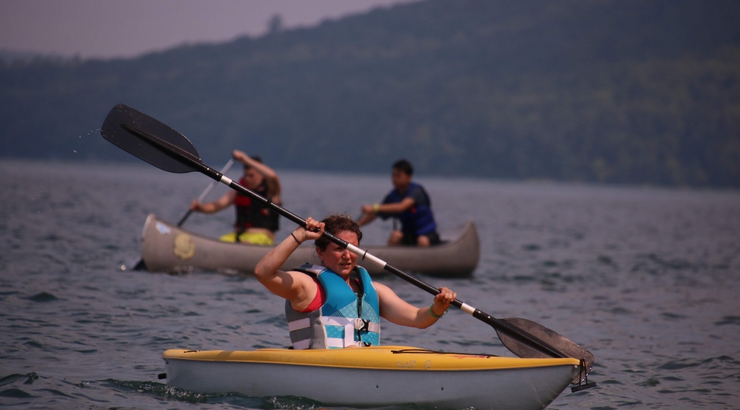 girl rows in a kayak boat on the lake